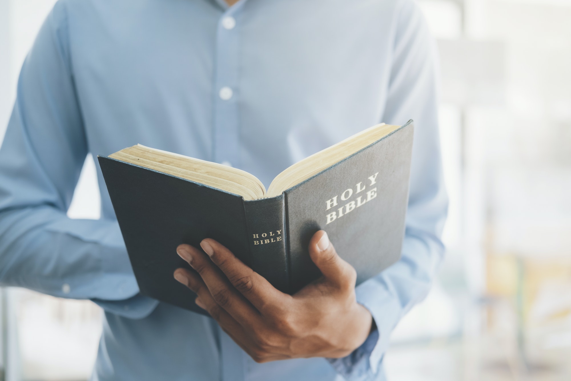 Man holding and reading the holy Christian Bible.