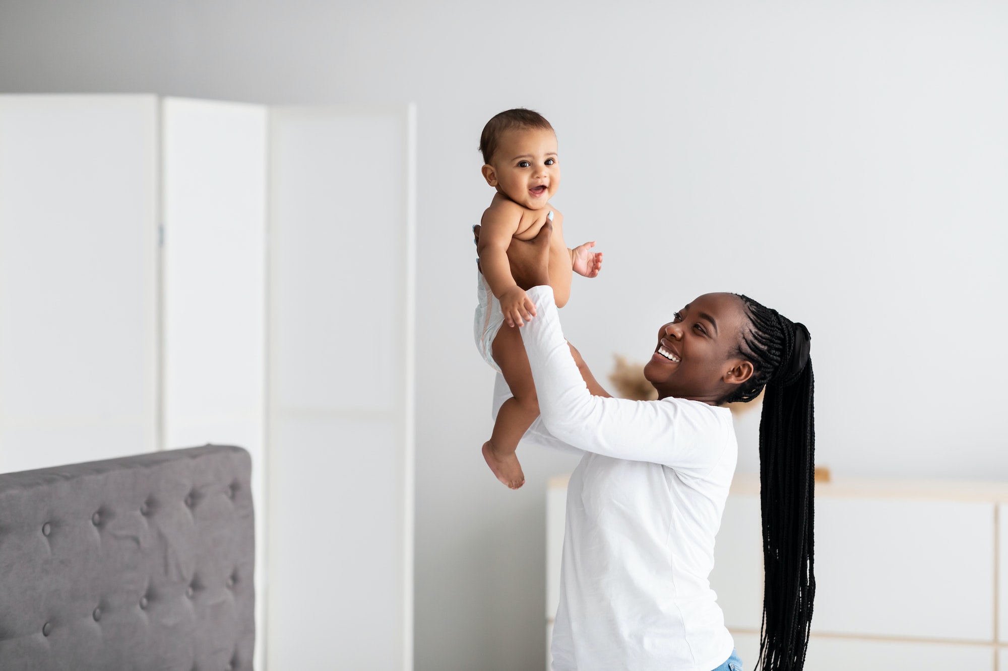 Black mom playing with her cute little baby