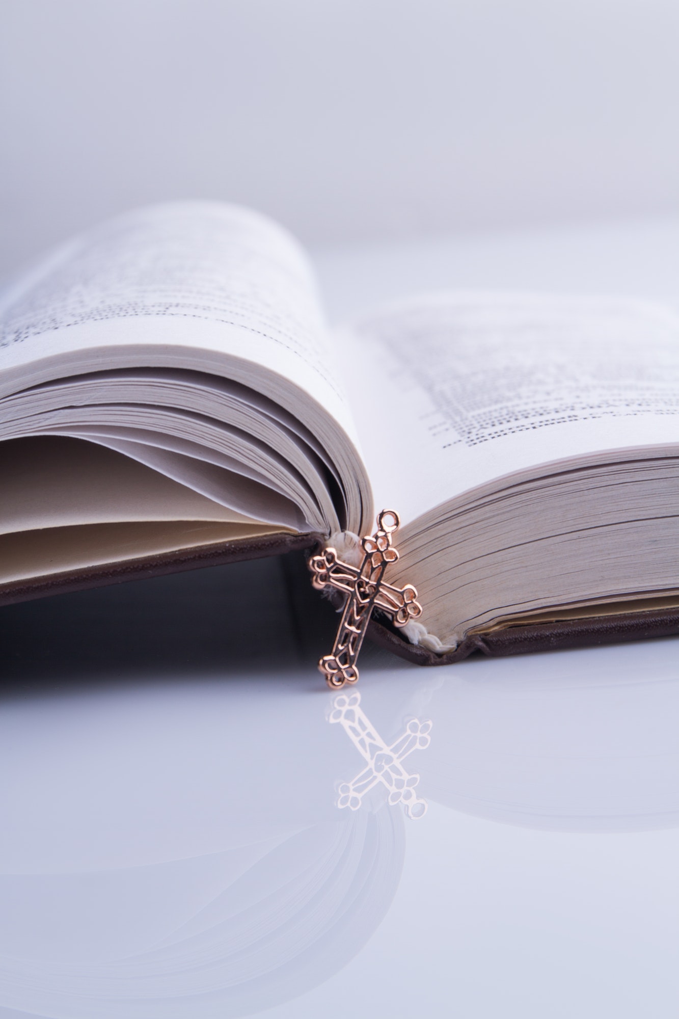 New opened holy bible and shiny golden cross.
