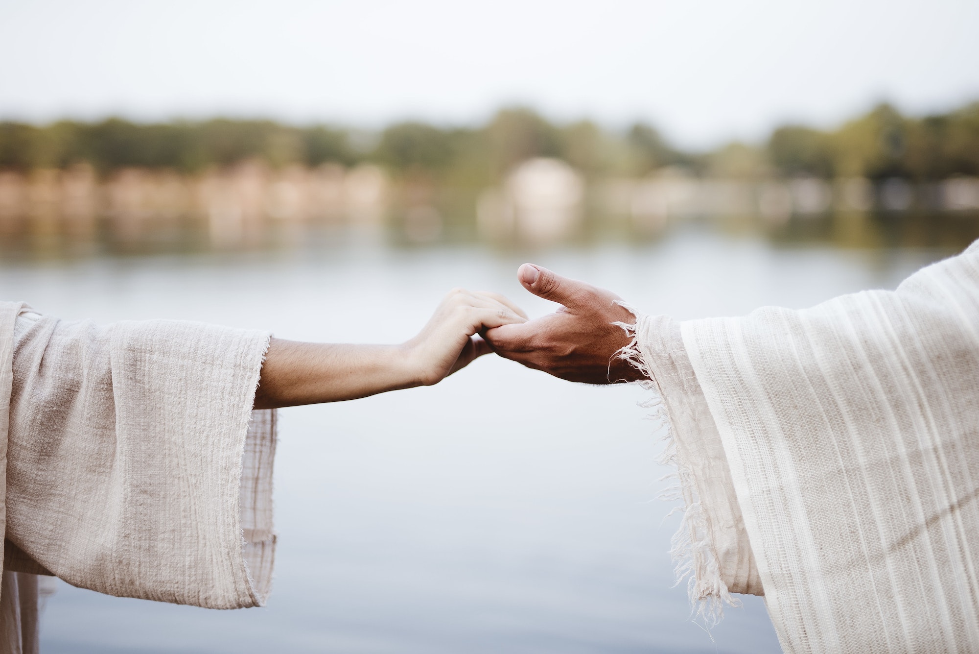 Biblical scene - of a female grabbing the hand of Jesus Christ with a blurred background