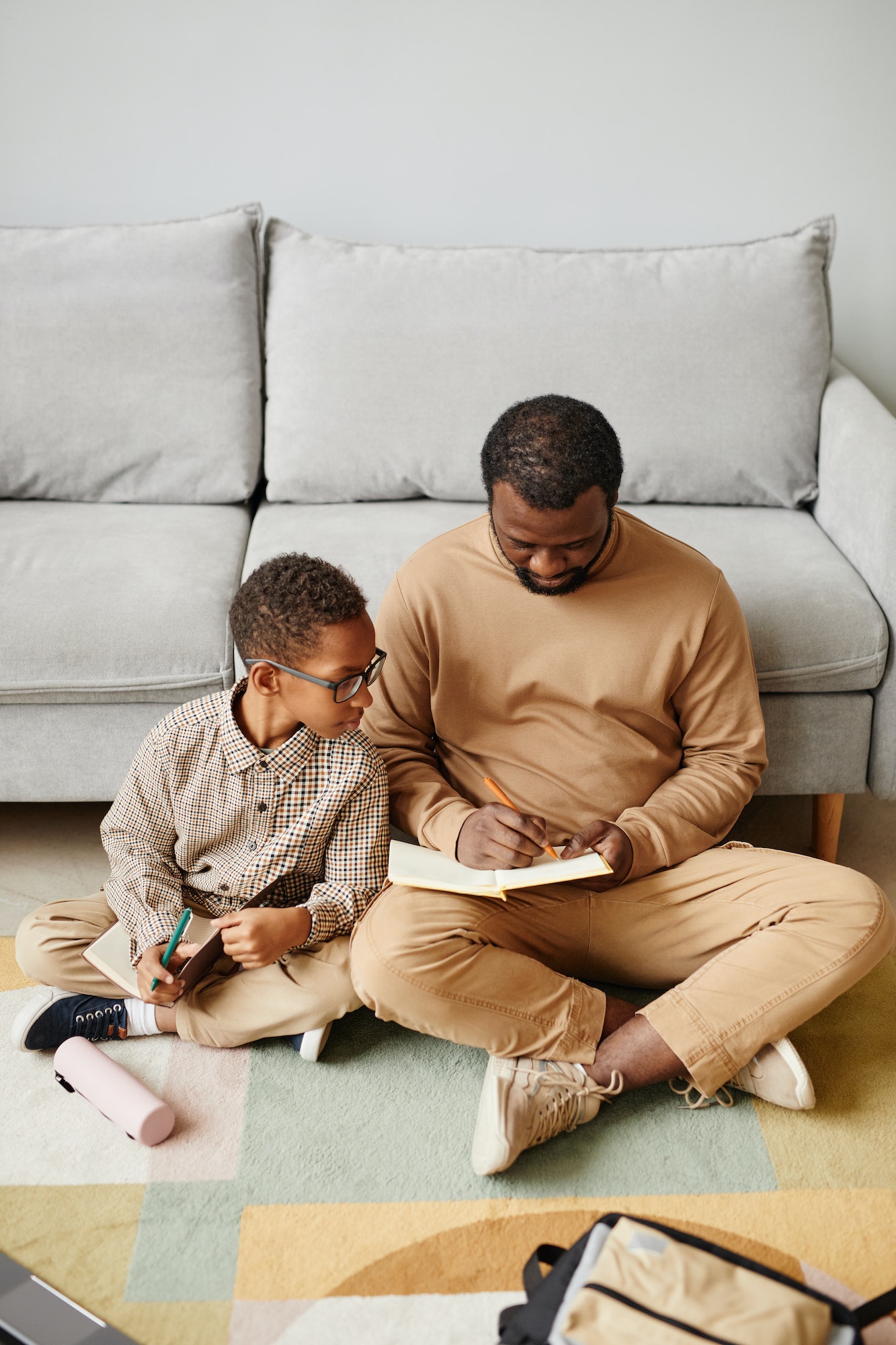 Father and Son Studying on Floor